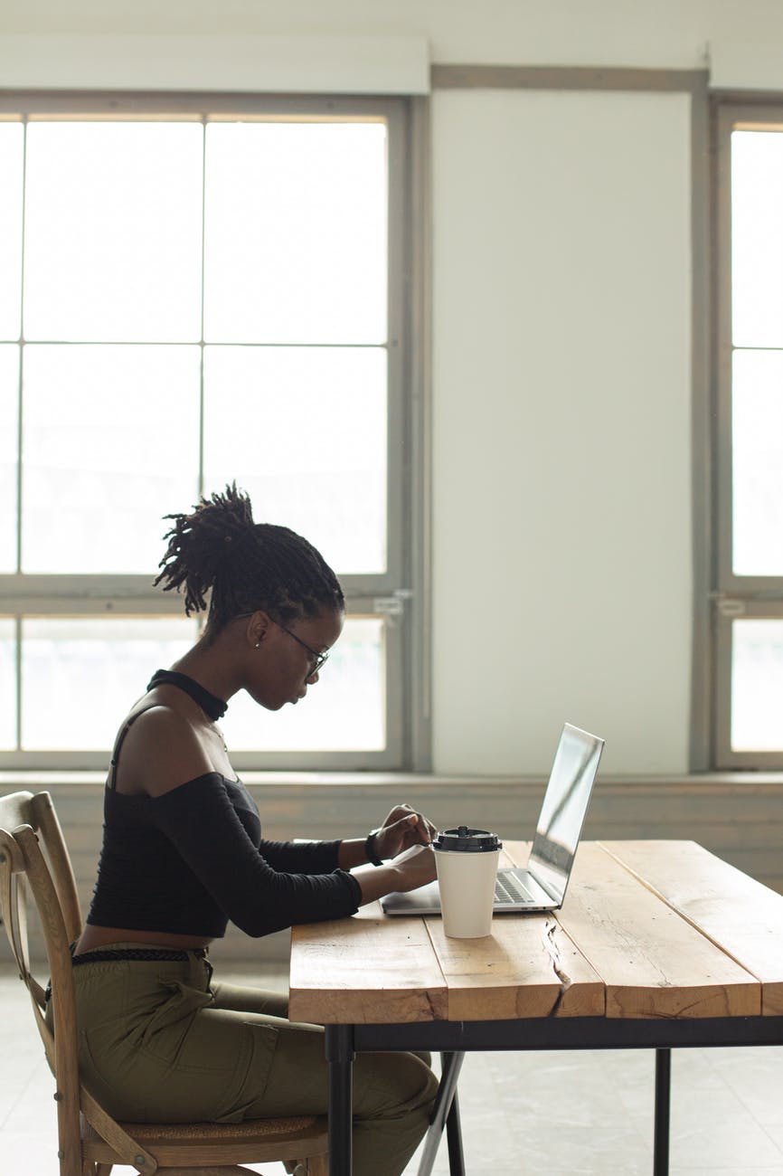 focused black woman using laptop