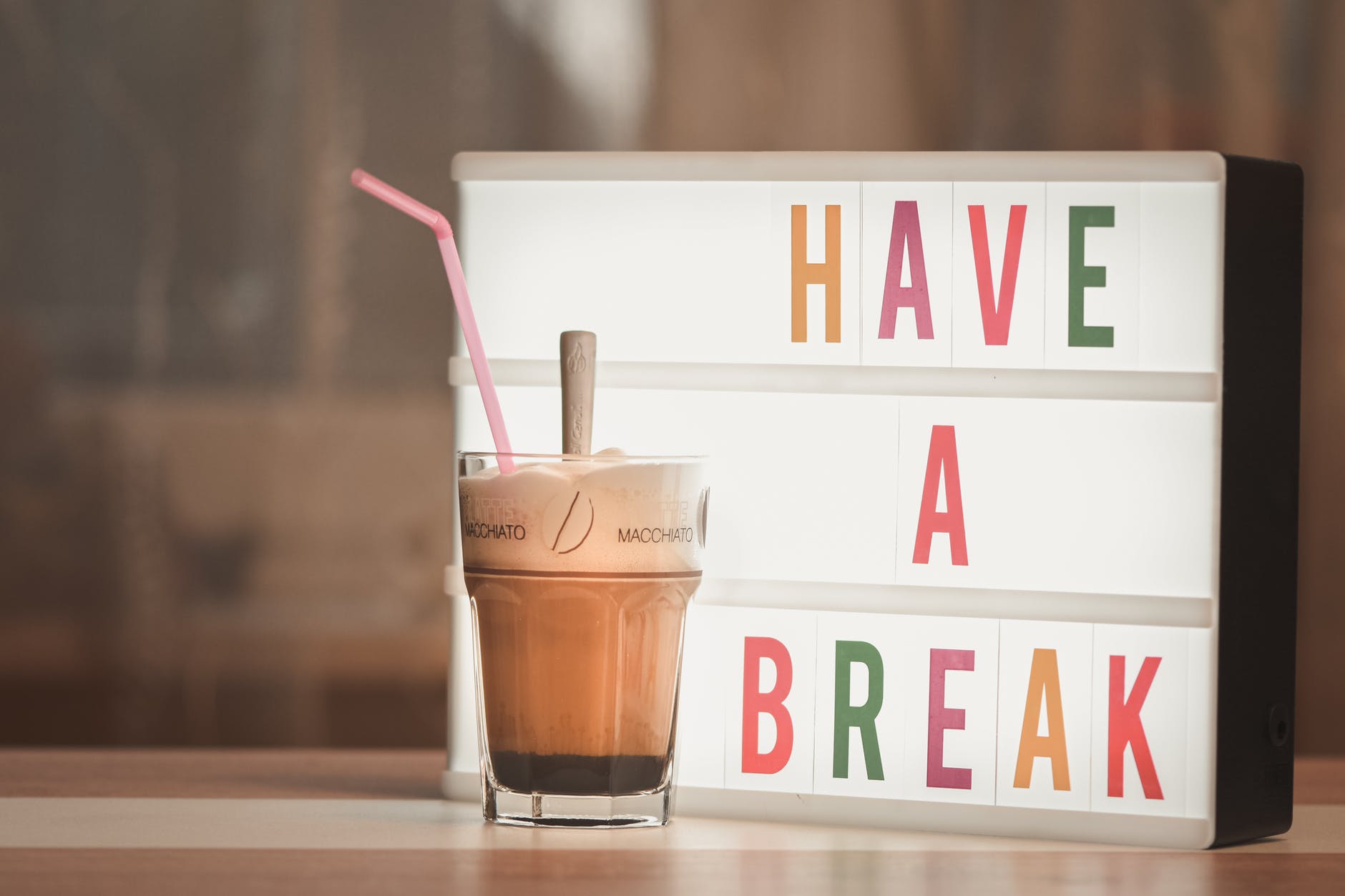a have a break signage beside a cup of macchiato